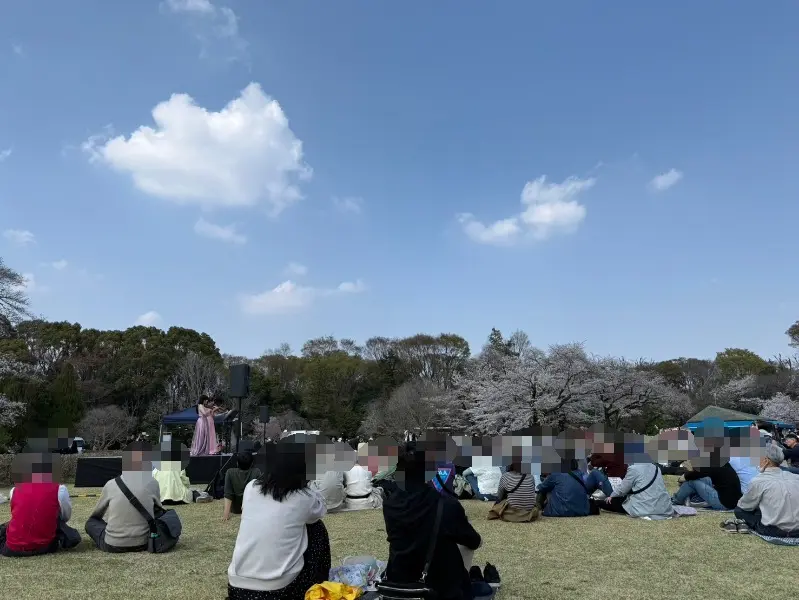芝生に座って音楽を楽しむ人たち