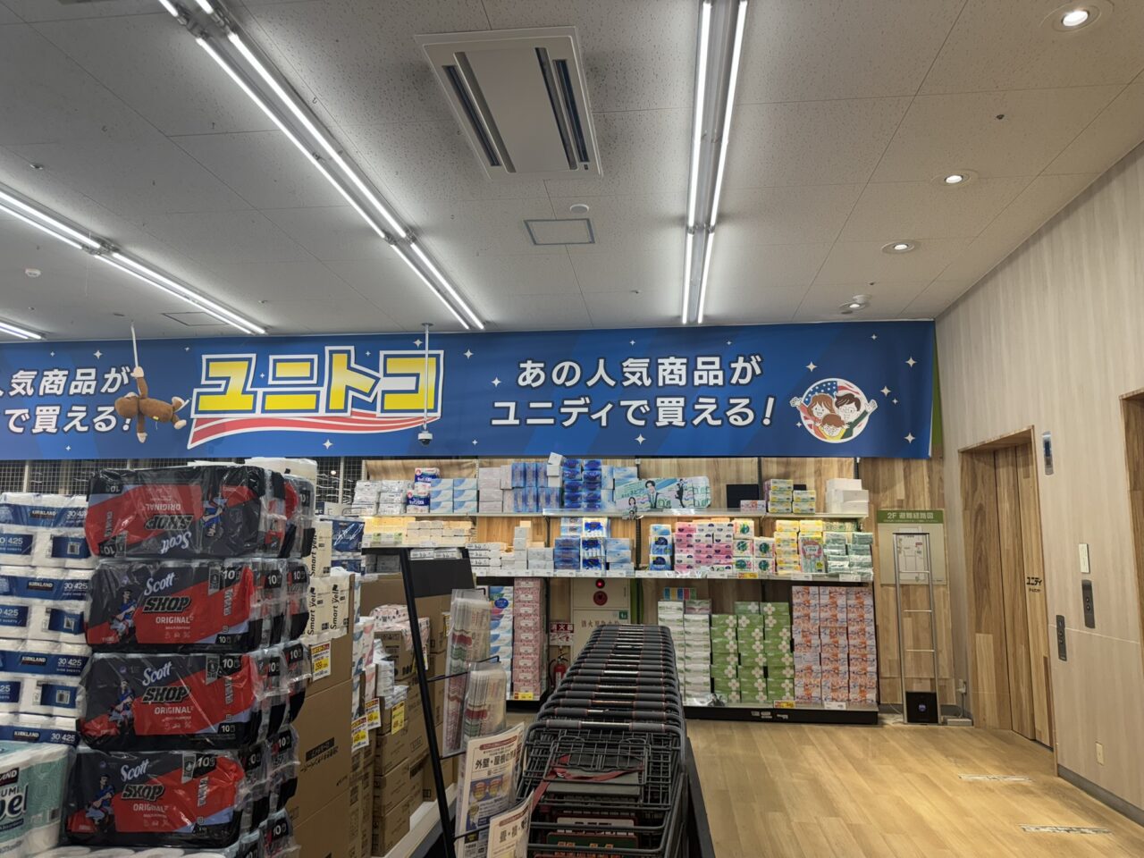 ユニディ狛江店の「あの人気商品がユニディで買える！ユニトコ」の売場看板と商品棚