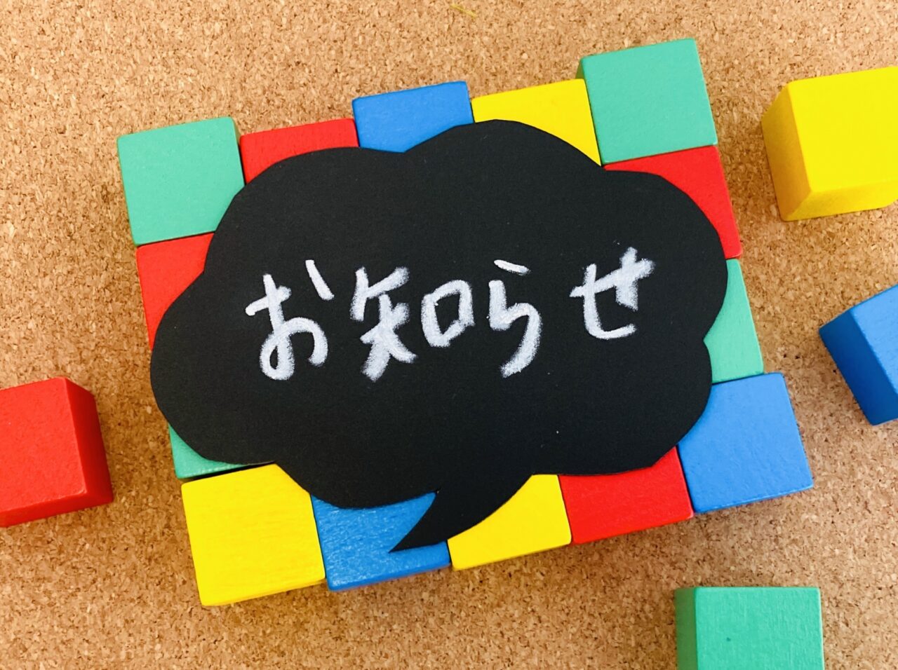 お知らせと書かれた吹き出しと積み木