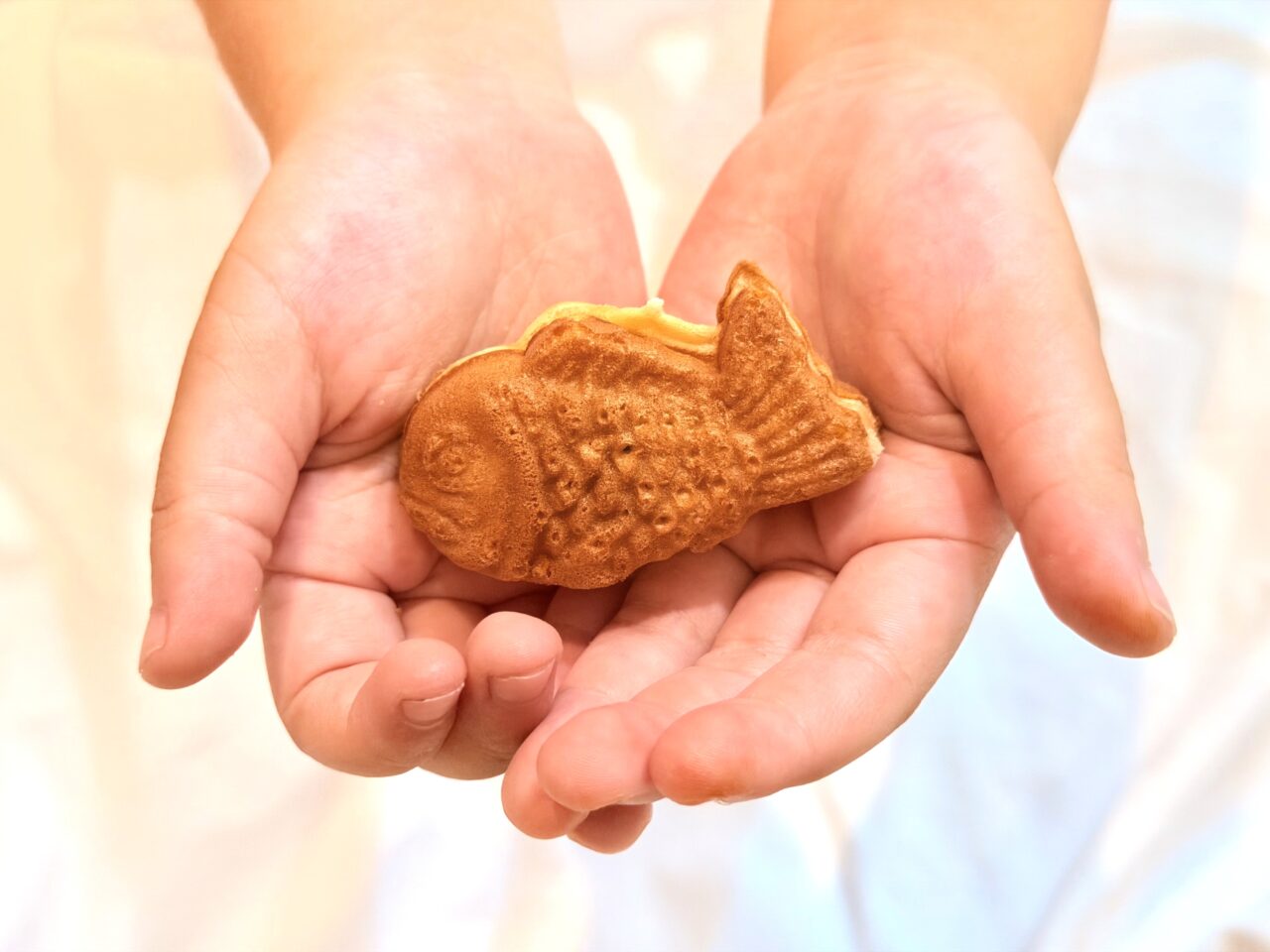 小さな子の手のひらに乗るミニたい焼き