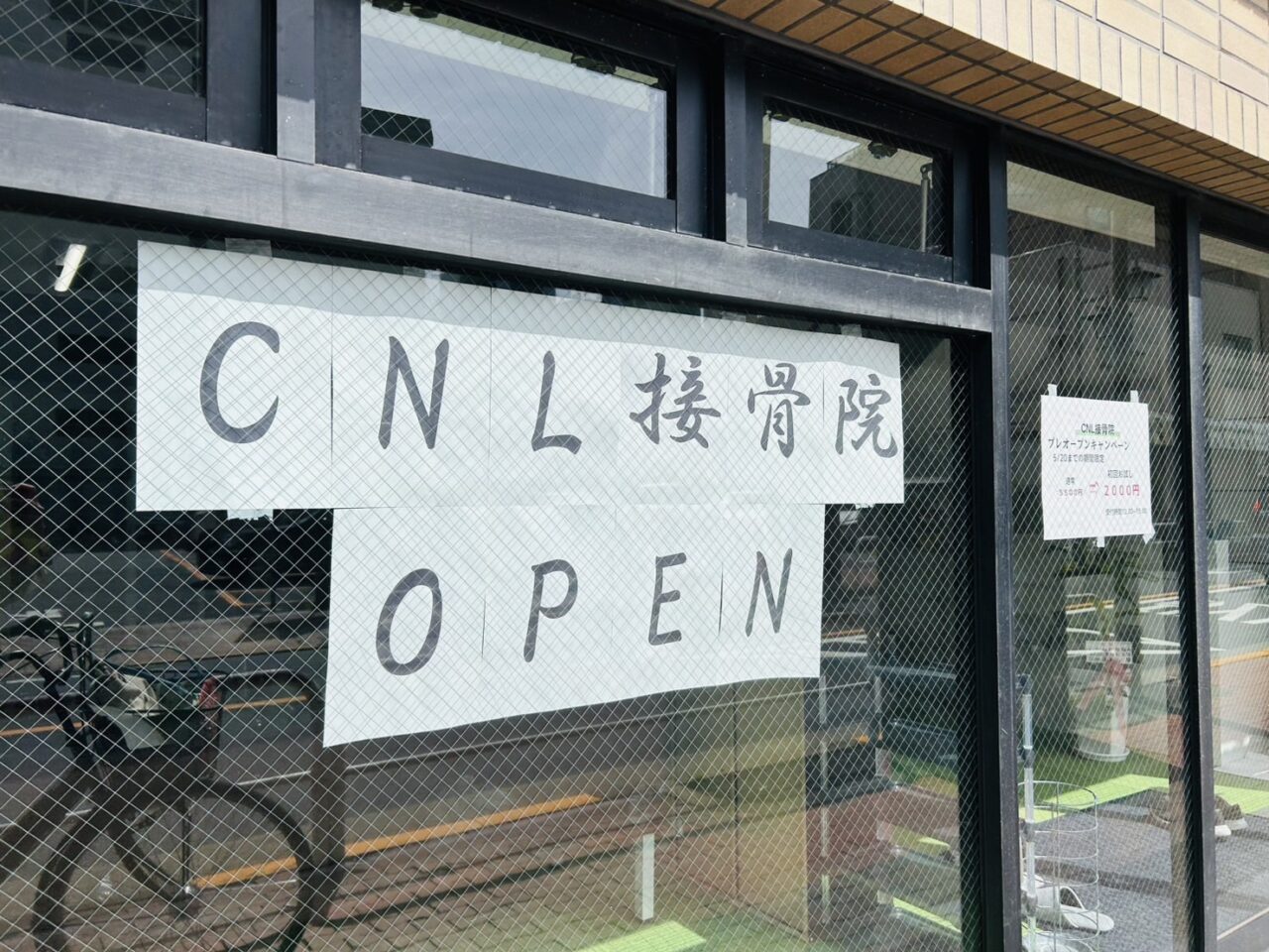 店頭ウインドゥの「CNL接骨院OPEN」の貼り紙