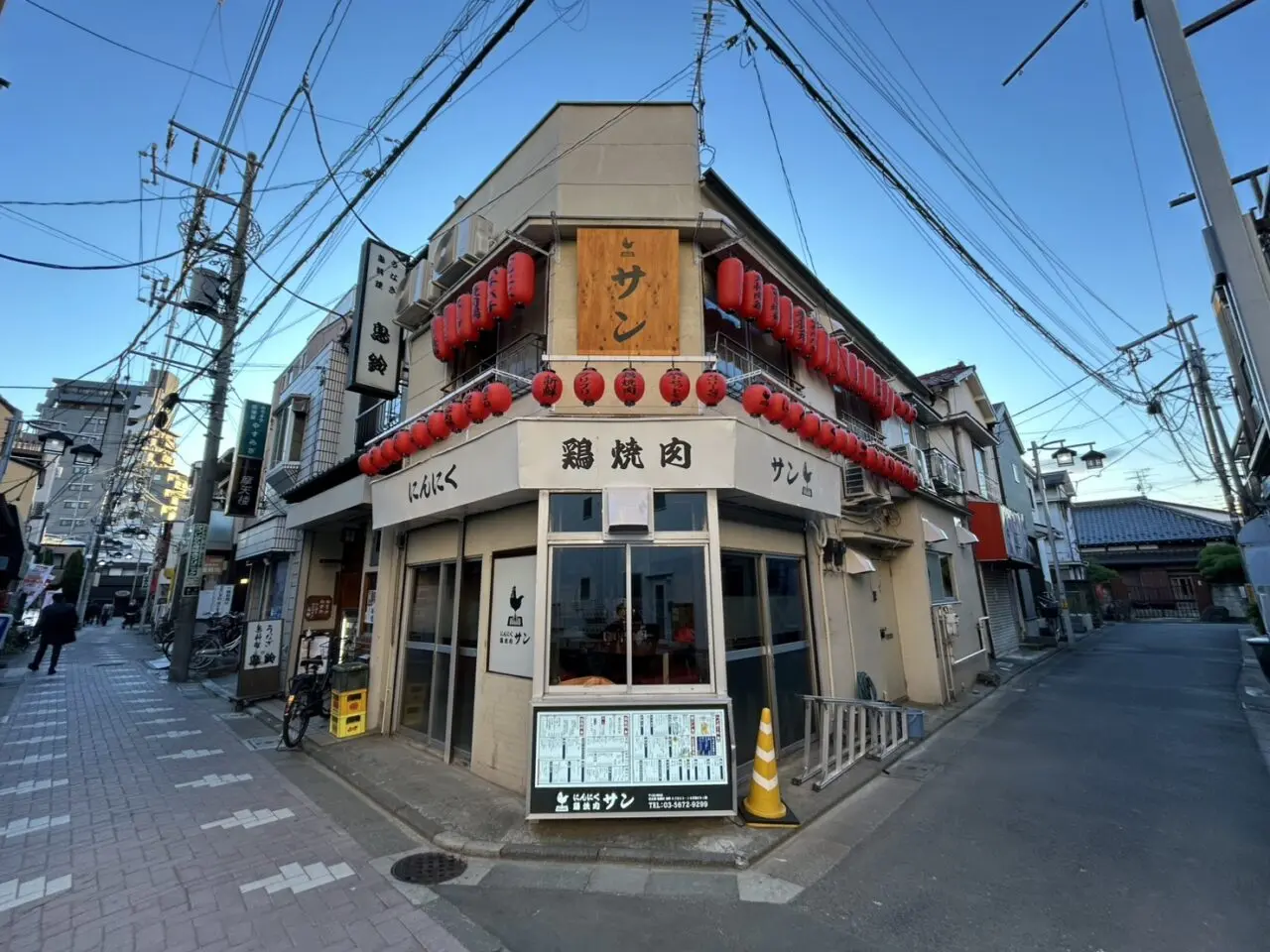 赤い提灯がずらりと並ぶ「にんにく鶏焼肉サン」の外観