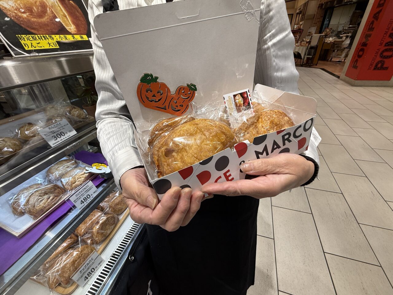 スタッフがアップルパイを手に持つ様子