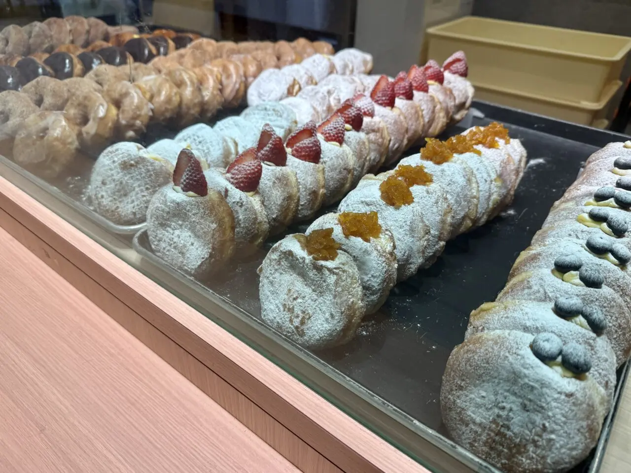 トレイにきれいに並んだ生ドーナツのディスプレイ