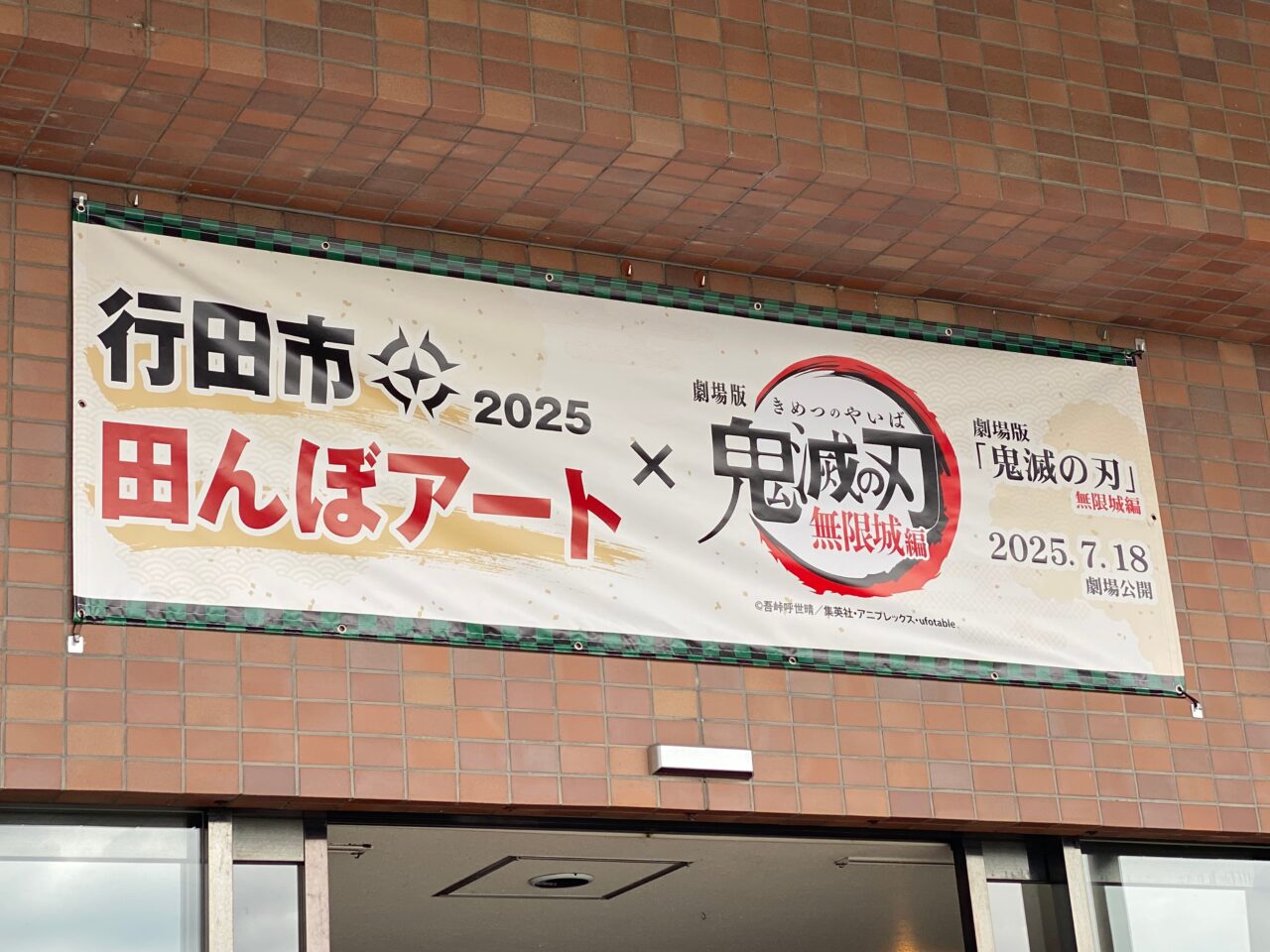 田んぼアートと鬼滅の刃のコラボをアピールする横断幕