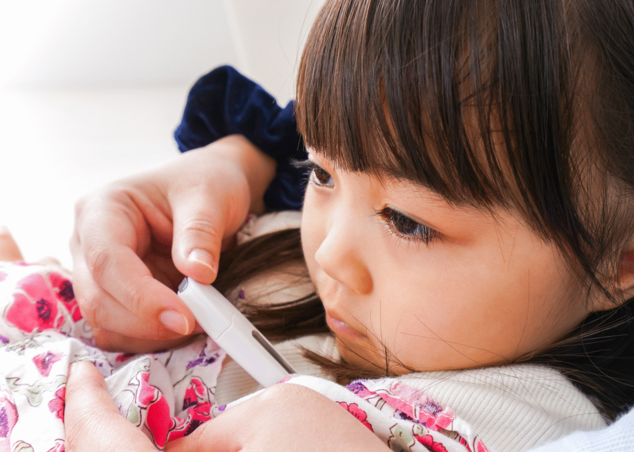 発熱した幼い子どもの体温を測っている様子のイメージ画像