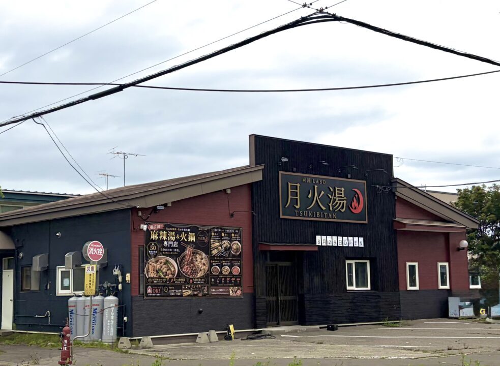 2026年8月29日（土曜日）にグランドオープンを迎える、本格シビ辛料理の専門店「麻辣LABO 月火湯（まーらーらぼ つきびたん）」の新規開店告知ビジュアル。店舗の所在地は「〒080-0051 北海道帯広市白樺16条西11丁目」で、地元で親しまれていた「元 麺屋弐式」の跡地。お店の最大の特徴である2つの営業スタイルを詳しく紹介しており、ランチタイム（営業時間 11:00〜14:15最終入店）は「昼は自分で選ぶ麻辣湯」として、好みの具材や辛さをカスタマイズして1人で気軽に楽しめるセルフスタイルの麻辣湯を提供。ディナータイム（営業時間 17:30〜21:15最終入店）は「夜はみんなで囲む火鍋」として、複数人で本格的なシビ辛スープを堪能できる火鍋専門店へと変わる。会計時の決済方法は、各種クレジットカードをはじめ、PayPayなどのQRコード決済、各種交通系電子マネーに幅広く対応している。公式Instagramアカウント（@tsukibitan）の案内とともに、背景には真っ赤なスープにスパイスが効いた、食欲をそそる本格的な麻辣湯と火鍋の料理イメージ写真が大きく掲載されている。